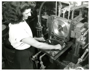 High-angle view of an unidentified woman as she lifts a copy of the Leon Rusk record 'Air Mail Special on the Fly' from a stamper at the King Record Company pressing plant, Cincinnati, Ohio, 1946. (Photo by Marsh Photographic Studio/Cincinnati Museum Center/Getty Images)